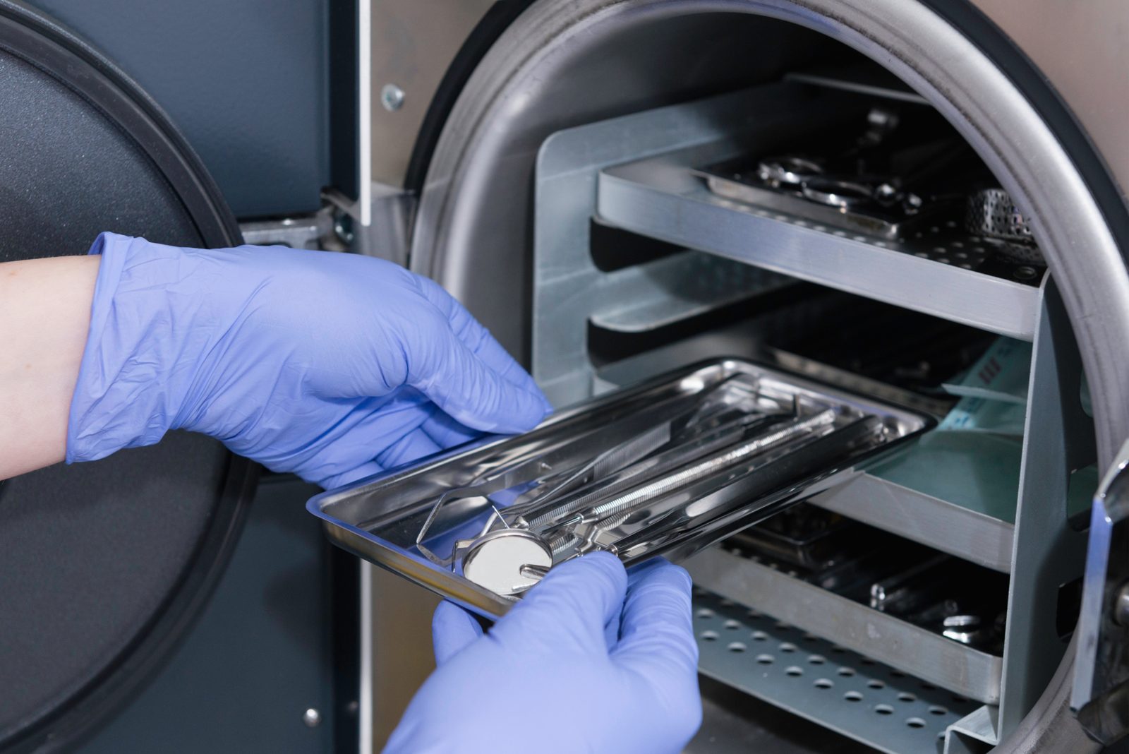 Plateau d'instruments emballés glissé dans un autoclave du centre