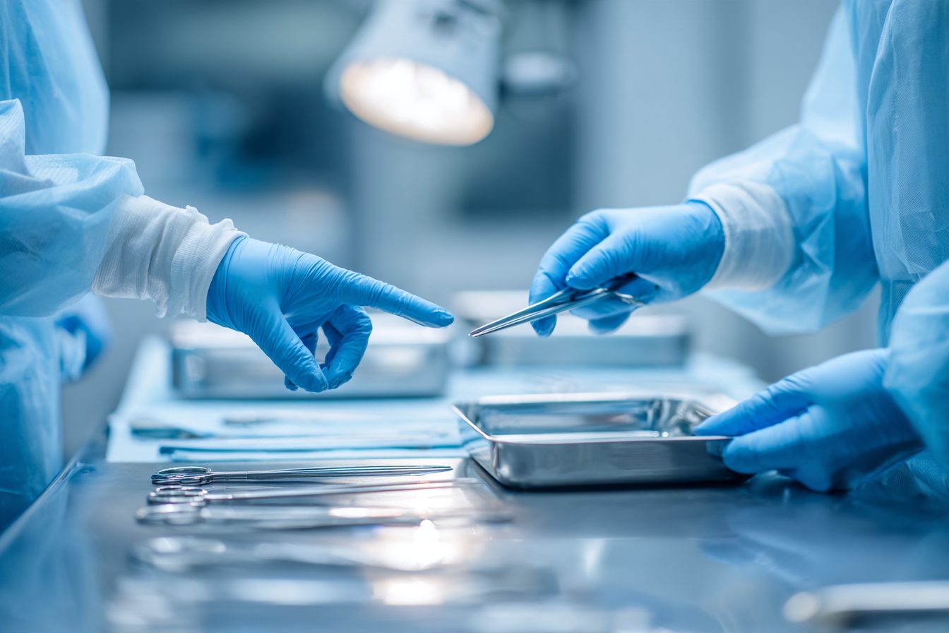 Deux technologues gantées préparent un plateau d'instruments au centre de stérilisation